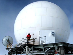 US Antarctic Program participant Nick Powell in front of the South Pole Marisat-GOES Radome.