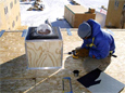 South Pole carpenter Jason Hunter assembles a casing for researcher Steven Mende’s electron precipitation all-sky camera.