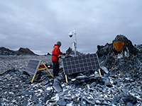 Communications technician Jason O'Brien installs a solar panel