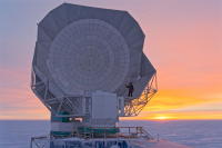 SPT winterover Dr. Karia Dibert clearing snow off of the telescope near sunset. Photo by Dr. Simeon Bash.
