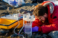 Researcher monitors device collecting water samples in Miers Valley. Photo by Mika Lucibella, courtesy of the USAP Photo Library.