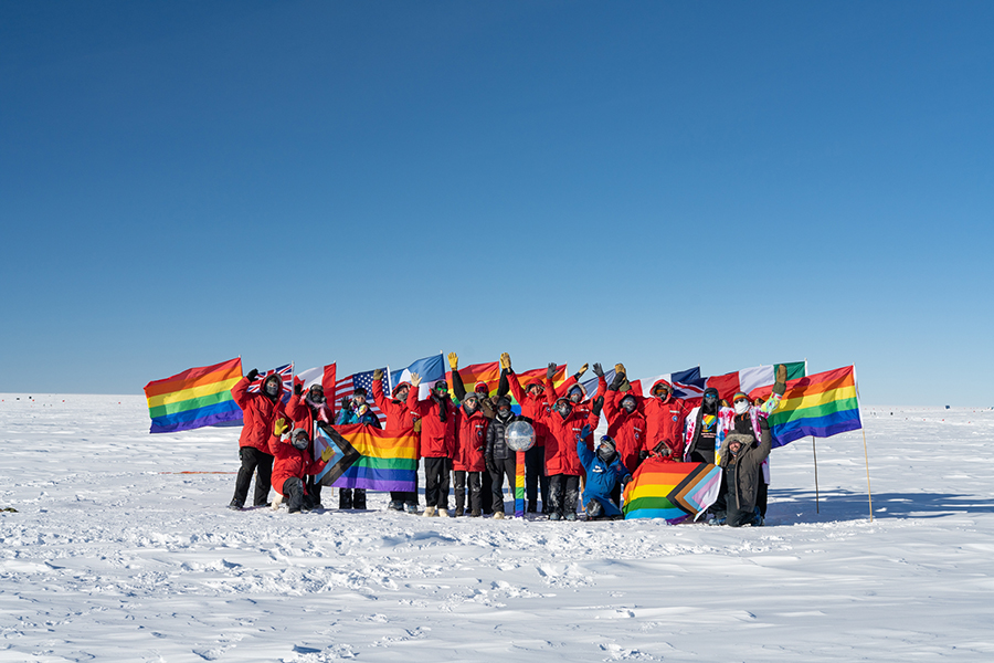 People wave pride flags at the South Pole
