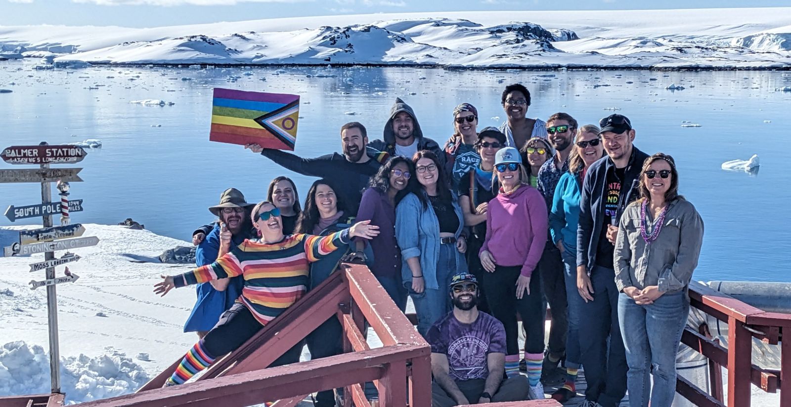 USAP Participants pose by a pride flag to celebrate 2023 Pride Day