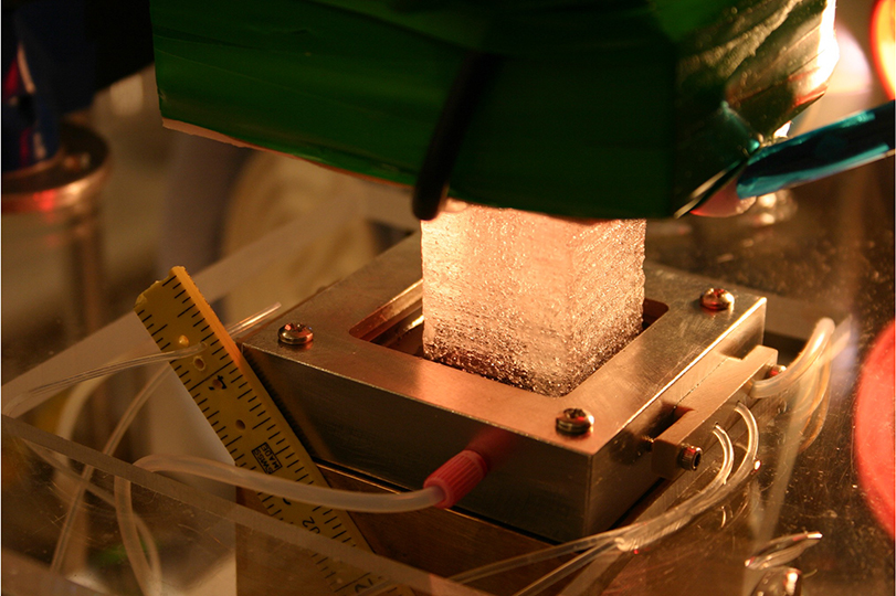 a cube of ice being pressed in a machine