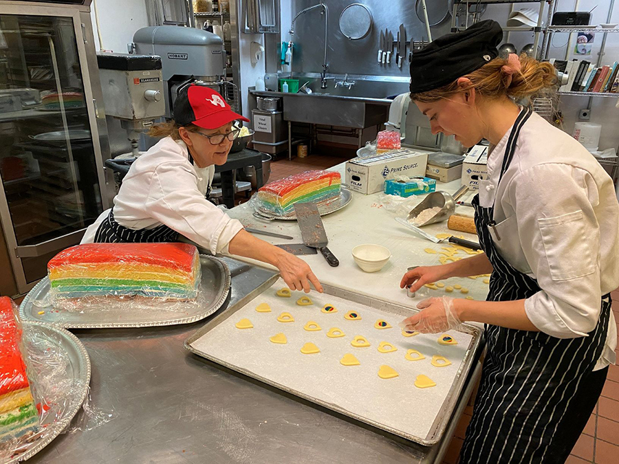 Bakers Caithlin Hull (Red Hat) and Katie Harris prepare rainbow-themed desserts at McMurdo Station. 